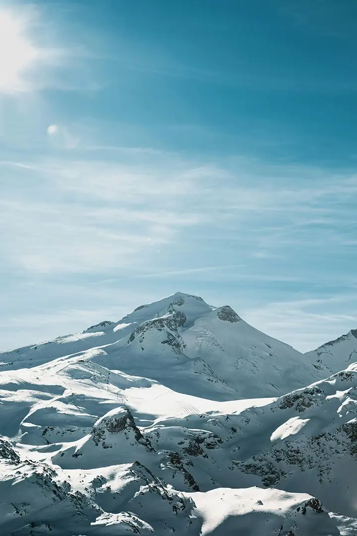 Sommet enneigé sous un ciel dégagé — une aventure Trekks dans un environnement de haute montagne, où chaque pas dans la neige rapproche le trekkeur d’un défi à débloquer, dans un univers gamifié et immersif.